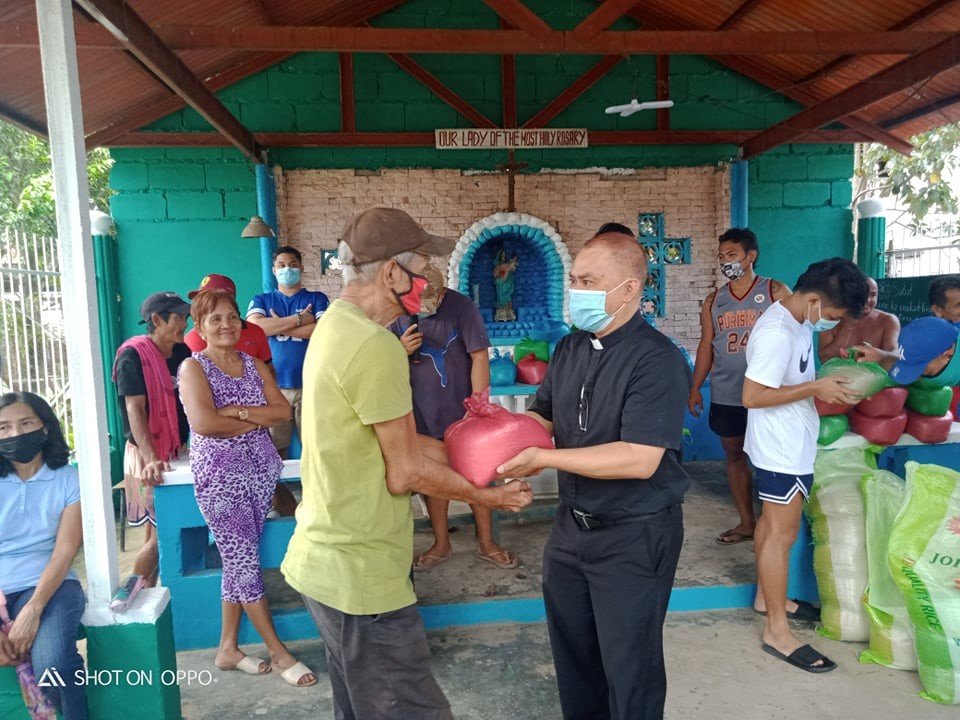 Father Donardo “Dandi” Bermejo’s coworkers at the Works of Charity Center in Manapla, the Philippines, fill bags of rice to distribute to people who were affected by a devastating super typhoon nine days before Christmas.